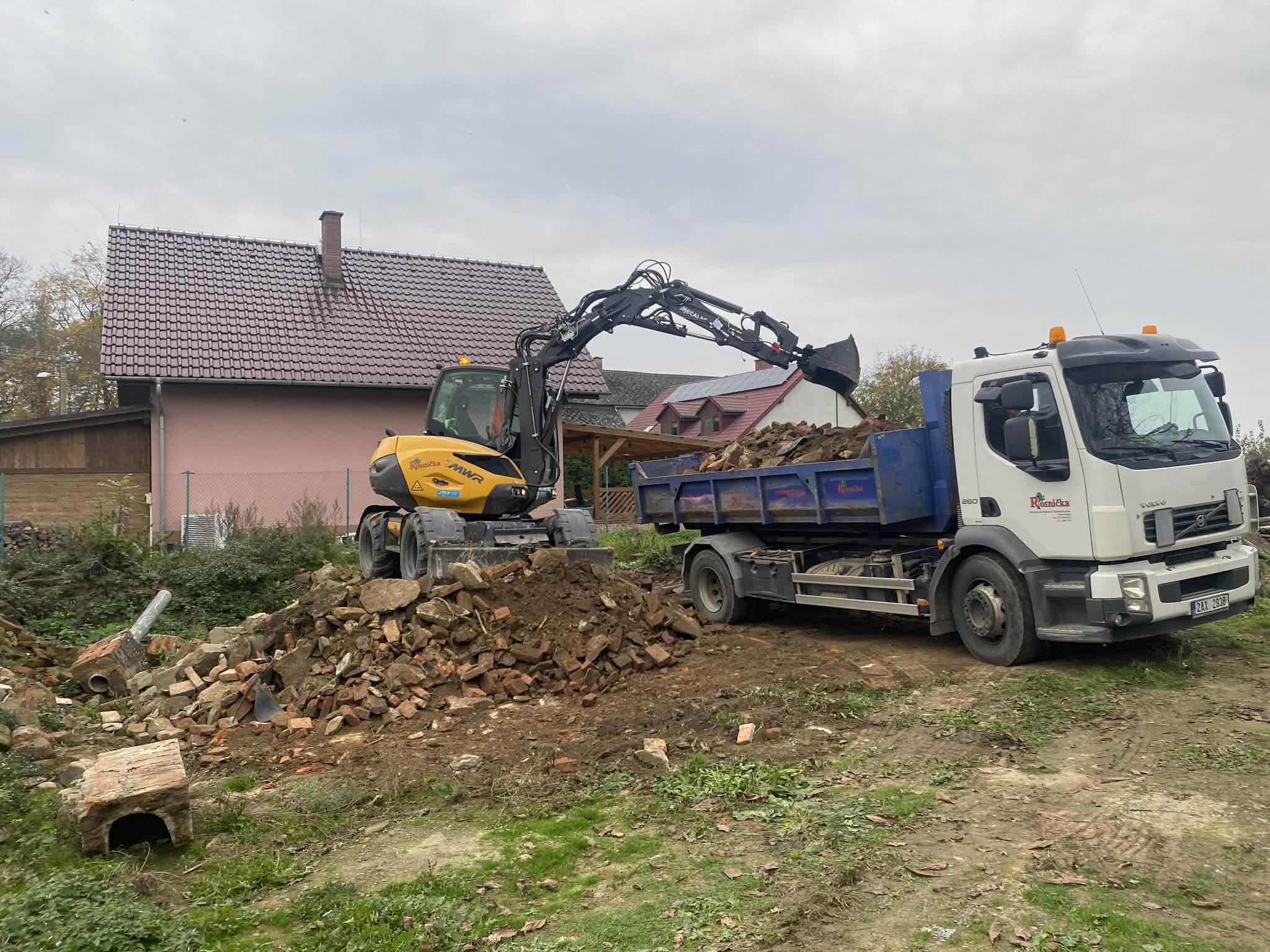Bagr nakládá materiál na auto